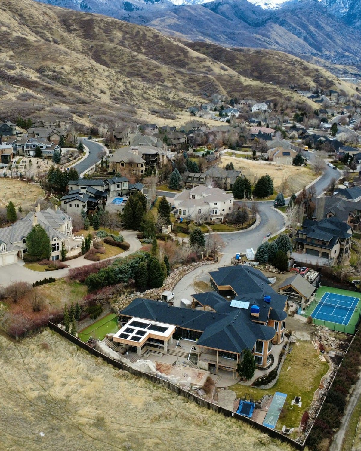 An aerial view of homes along a winding hillside road